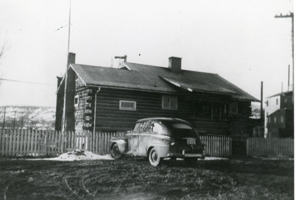 Black and white photograph of Manhattan Project headquarters in Grand Junction - a small log cabin