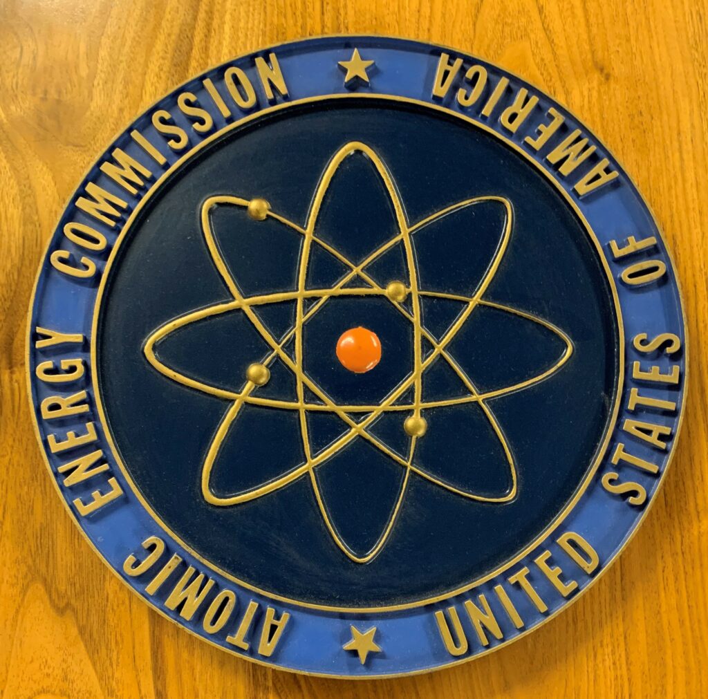 Atomic Energy Commission plaque -- blue circle around a black field, with an atomic symbol in the center.