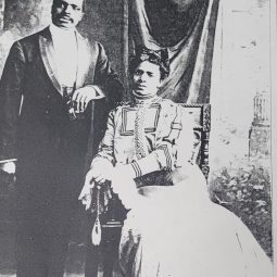 A portrait of John and Amanda Hines - she is seated, he's standing near her shoulder. They're elegantly dressed.