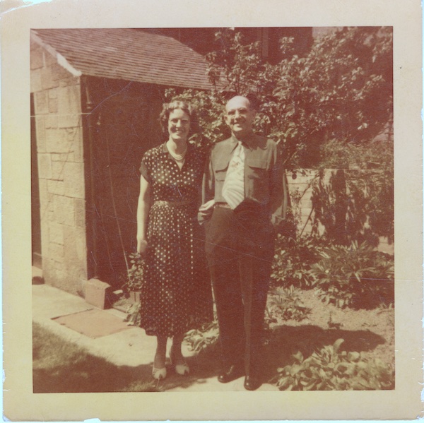 Photo of a couple in front of a house.